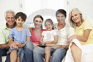 Extended Family Relaxing On Sofa At Home Together