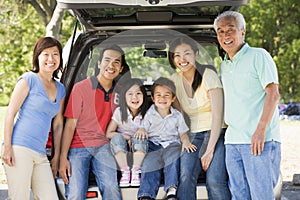 Extended family sitting in tailgate of car photo