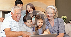 Extended family using the laptop together on the couch