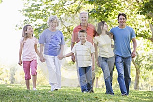 Extended family walking in park holding hands photo