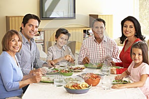 Extended Hispanic Family Enjoying Meal At Home