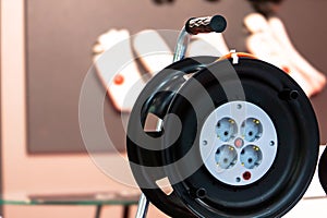 Extension cord on a reel with grounding for 4 black sockets