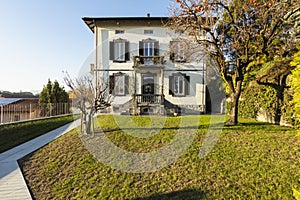 Exterior ancient villa with well-kept garden on a sunny day