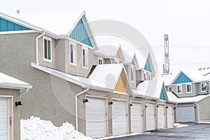 Exterior of apartments on a snowy neighborhood with wet road and cloudy sky