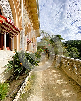 Exterior architectural details of a mansion lined with flowers and plants