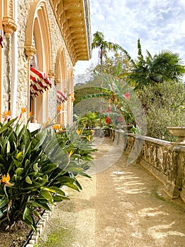 Exterior architectural details of a mansion lined with flowers and plants