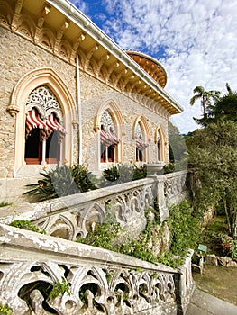 Exterior architectural details of a mansion lined with flowers and plants