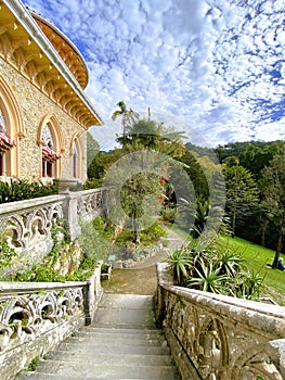 Exterior architectural details of a mansion lined with flowers and plants