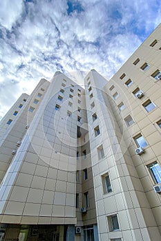 Exterior casual urban modern business high-rise office building architecture with sky clouds. Noise, film grain as artistic effect