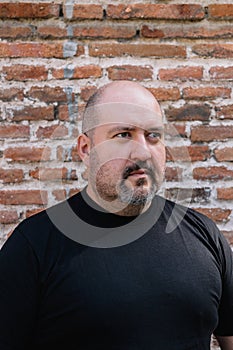 Exterior close-up of a 45-year-old bald man with a goatee and mustache looking to the right