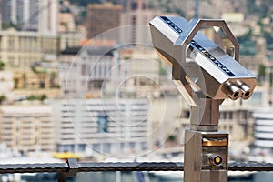 Exterior of the coin operated binocular at the viewpoint with the urban panorama at the background in Monaco.