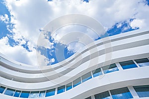 Exterior Of Curved Glass Modern Office Building on a Blue Sky Background