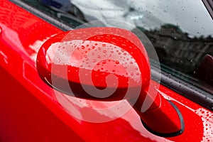 Exterior details of a luxury car. Red car side mirror close-up