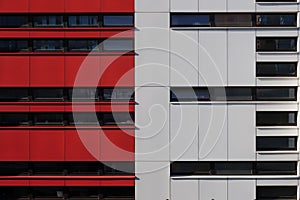 Exterior facade of modern building with detail of red and white aluminium panels.