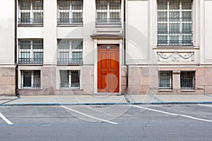 Exterior facade of an old stone building with a classic red wooden door and windows