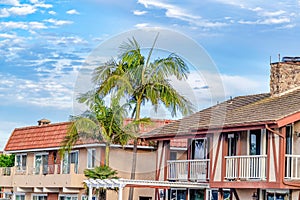 Exterior of homes with private balconies against blue sky and clouds background