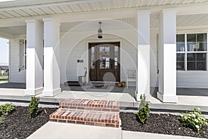 Exterior of a house with brick stairs, plants and white walls