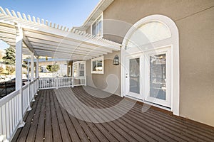 Exterior of a house with white handrails and wood plank flooring