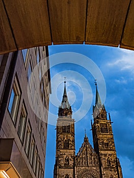 Exterior image of St. Lorenz church in the old town of Nuremberg seen through the arch of a building, Germany