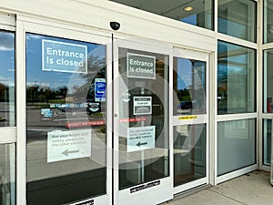 The exterior of a Kohl`s department store with signs warning that one of the entrances is closed due to coronavirus