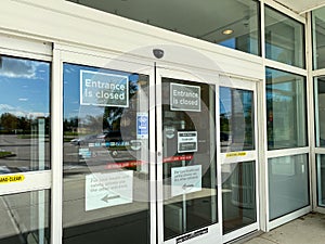 The exterior of a Kohl`s department store with signs warning that one of the entrances is closed due to coronavirus