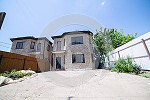 Exterior of a large two story brick residential home containing plenty of copy space