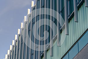 Exterior of a modern building with vertical sunshades outside the glass windows