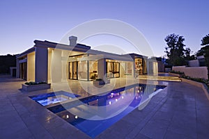 Exterior of modern home with swimming pool at dusk