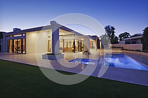 Exterior of modern home with swimming pool at dusk