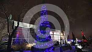 Exterior of modern house or restaurant, the Christmas lights are lit on the trees, in the night sky, camera movement