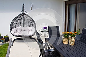 Exterior of modern house terrace with swinging chair or summer seat