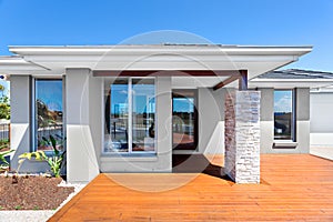 Exterior of a modern house with a wooden floor with blue sky