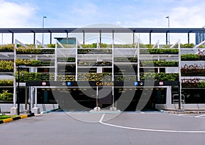 Exterior of modern multi-storey carpark building structure, with lush green plants on the facade - eco green wall. Architectural