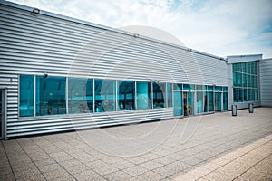 Exterior of a modern steel and green glass office building with empty walkway. panoramic and perspective view. Abstract