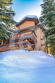 Exterior of multi storey family home sitting on hill with snow in winter season photo