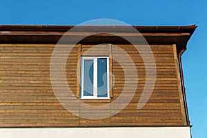 The exterior of a new modern wooden house and double-glazed windows in wooden walls. Design and architecture of private houses.