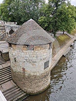 Exterior of North Street Postern medieval Tower with trees by the lake