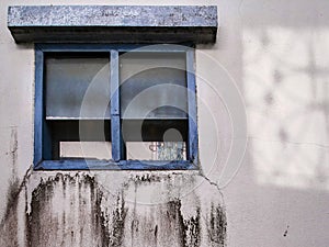 Exterior of old tropical house with black mold and cement crack on wane wall outside bathroom