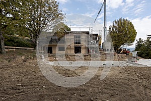 Exterior old villa under construction. The garden has disappeared and the pool is already being excavated