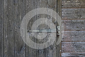 Exterior of old weathered wooden shed showing door and hinge detail