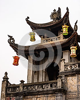 Exterior of Phat Diem Cathedral in Northern Vietnam with spires, cross, doorways, and lanterns