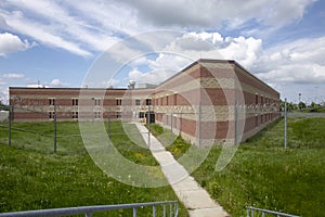 Exterior of prison cell block with overgrown yard