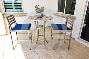 Exterior Rear Patio With High Table And Two Chairs With Blue Cushions