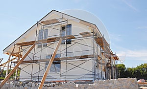 Exterior renovation of the house by rendering, insulating, plastering, applying stucco and painting the facade of the house on