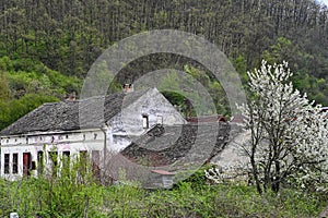 Exterior of the ruins of an old village abandoned house with a ruined tiled roof