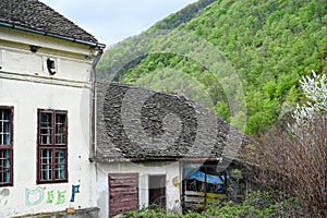 Exterior of the ruins of an old village abandoned house with a ruined tiled roof