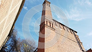 Exterior shot of an old red brick building. Abandoned factory with a tall chimney