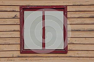 Exterior of a shuttered window on old weatherboard wall