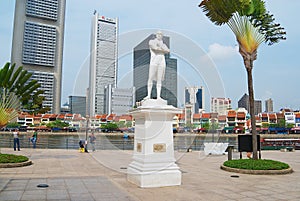 Exterior of the Sir Thomas Stamford Bingley Raffles statue with modern buildings at the background in Singapore, Singapore.