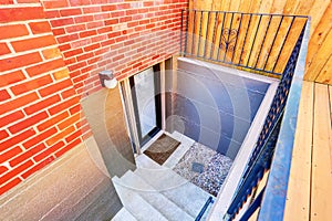 Exterior steps lead to underground basement of the brick house